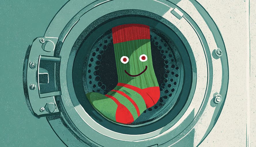 A single green and red striped sock with a smiley face inside a washing machine.